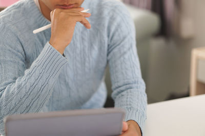 Midsection of man using mobile phone