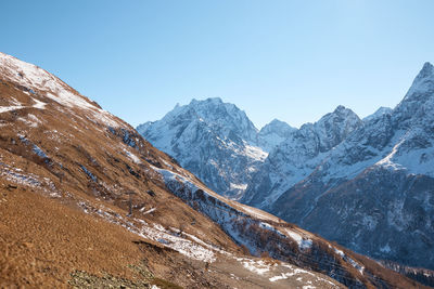 Scenic view of snowcapped mountains against clear blue sky