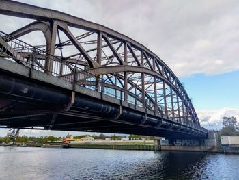 Low angle view of bridge over river against sky