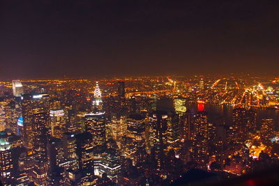 Illuminated cityscape against sky at night