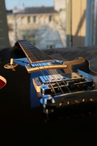 Close-up of electric guitar on sofa