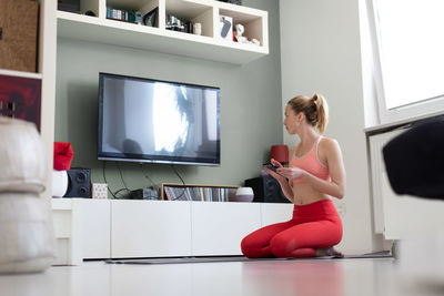 Rear view of young woman sitting on sofa at home