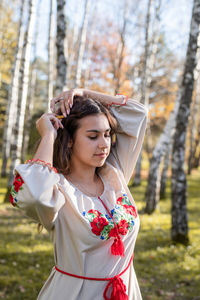  beautiful woman in national ukrainian national traditional costume clothes walking in forest