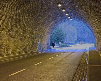 Rear view of man on road in tunnel