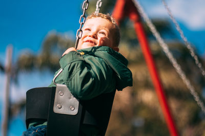 Portrait of little boy swinging