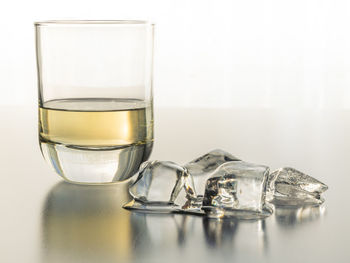 Close-up of beer glass on table against white background