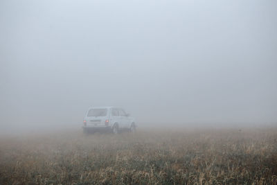 Car on field during foggy weather