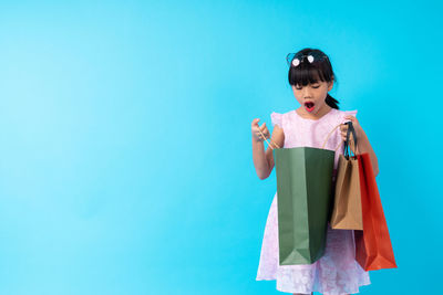 Smiling girl standing against blue background