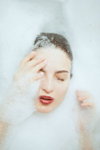 Close-up of young woman with eyes closed in bathroom