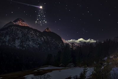 Scenic view of snowcapped mountains against sky at night