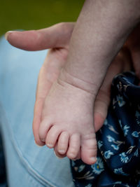 Close up of a baby foot being held in the hand of his or her mother