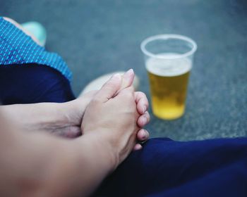 Midsection of woman sitting by beer glass