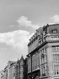 Low angle view of buildings against cloudy sky