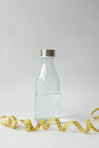 Close-up of glass bottle on table against white background