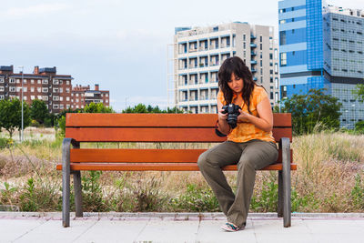 Full length of woman sitting on bench