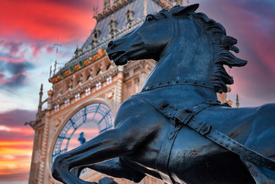 Close up view of the big ben clock tower and horse statue monument in the foreground.