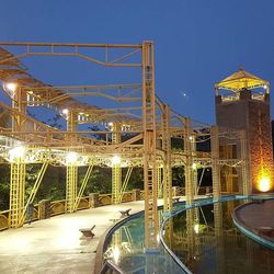 Illuminated factory against sky at night