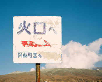 Close-up of road sign against blue sky