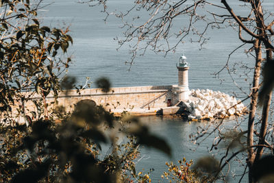 Lighthouse by sea against sky