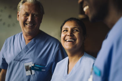 Cheerful multiracial male and female doctors in blue scrubs at hospital