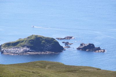 High angle view of rocks on shore against blue sky