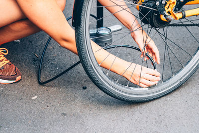 Cropped image of man pumping bicycle tire on street