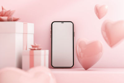 Close-up of hand holding mobile phone on table