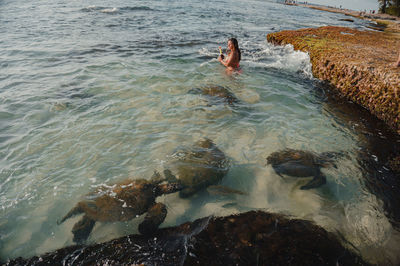 High angle view of woman standing in sea