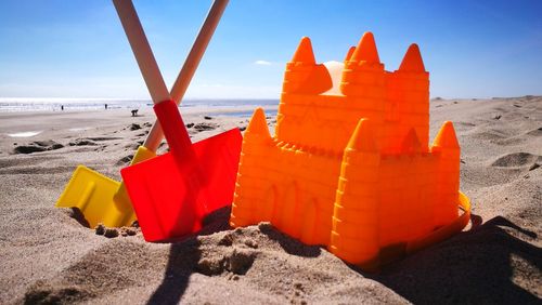 Close-up of plastic castle and shovels on beach