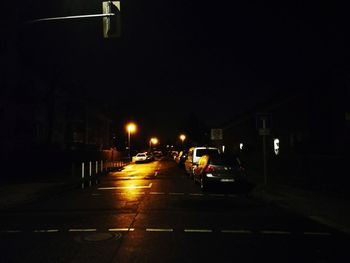 Cars on illuminated street at night