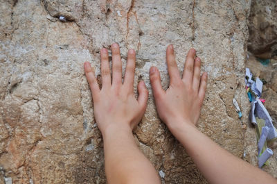 Close-up of hands touching rock formation