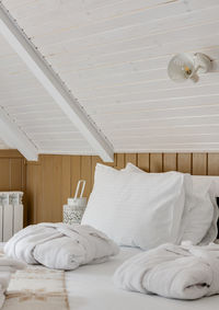 Close-up of the hotel room with white linens and white bathrobes on the bed