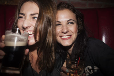 Portrait of a smiling young woman drinking glass