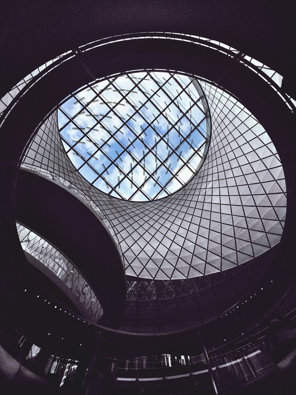indoors, architecture, built structure, low angle view, ceiling, skylight, circle, pattern, geometric shape, arch, glass - material, window, architectural feature, design, interior, shape, building, directly below, no people, building exterior