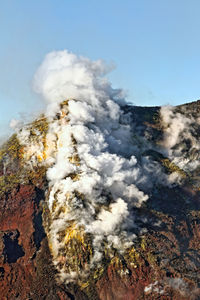 Low angle view of clouds against rocky landscape