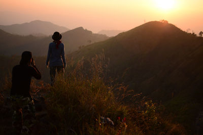 People standing on mountain during sunset