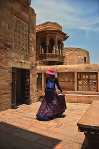 Rear view of woman walking at historic building