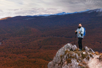 Full length of man standing on rock against mountains