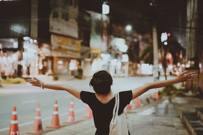 Cinematic style of young women raise her arm in freedom emotion with street night light