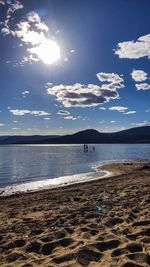 Scenic view of beach against sky on sunny day