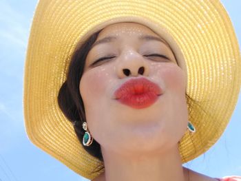 Low angle close-up of woman with eyes closed puckering lip