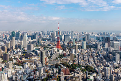 Aerial view of buildings in city against cloudy sky