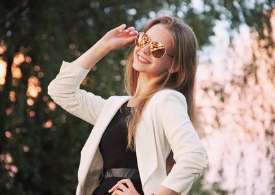 Beautiful young woman wearing sunglasses outdoors