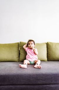 Boy sitting on sofa at home