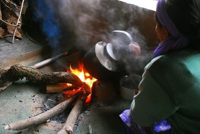 High angle view of person cooking food on fire