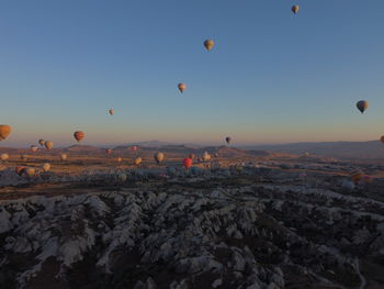 Hot air balloons flying against sky during sunset