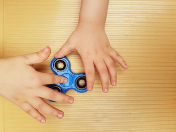Close-up of hand playing with fidget spinner on table