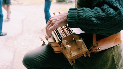 Midsection of man holding musical instrument