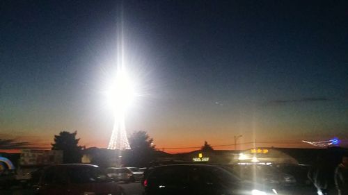 Illuminated city against clear sky during sunset