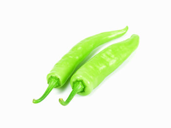 Close-up of green chili pepper against white background